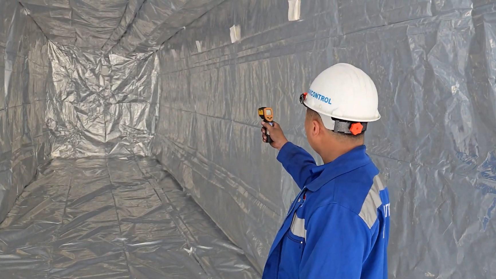 How Sawdust Charcoal Briquettes Manufacturers Ensures Quality for Global Markets 6 A professional inspector is checking the temperature inside a container