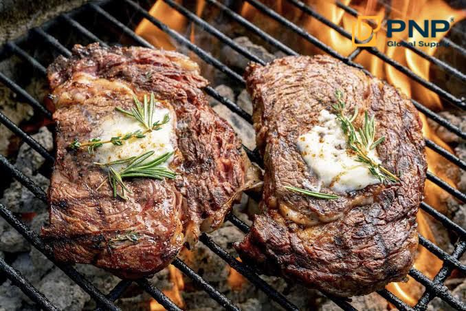 Grilling steaks on charcoal creates a rich, browned crust